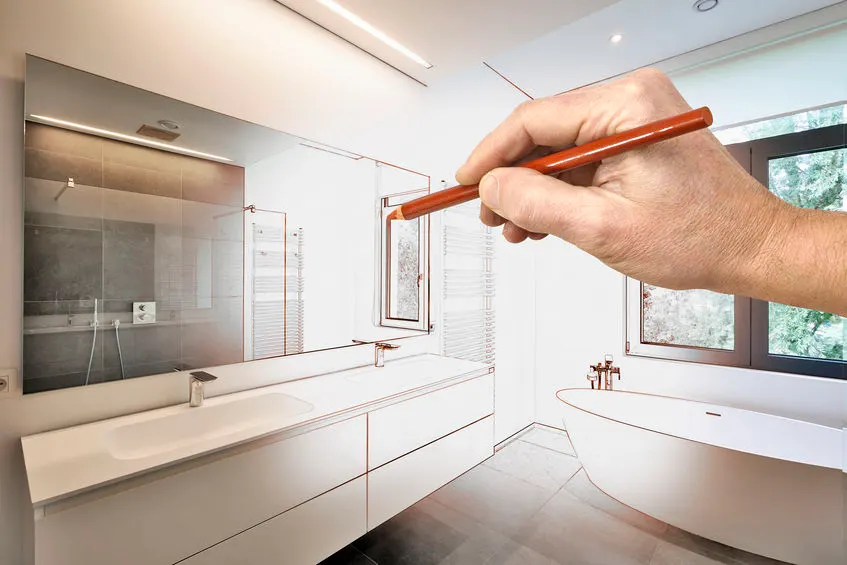 Hand sketching a bathroom remodel plan over a finished bathroom