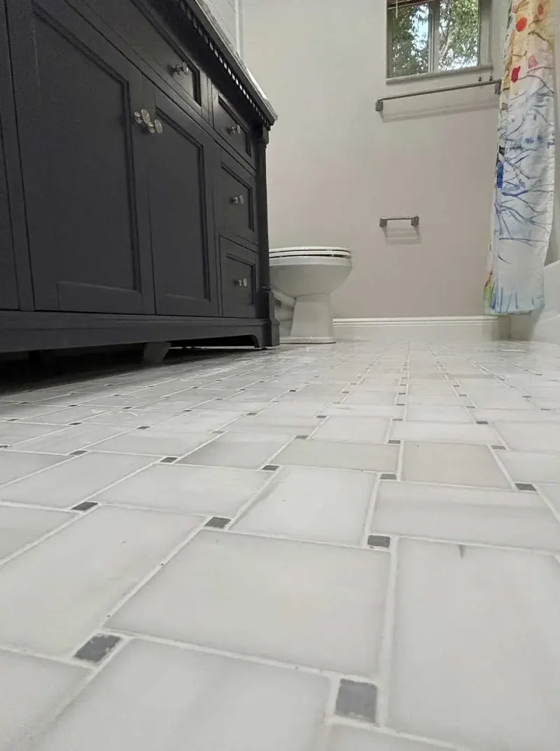Finished bathroom floor tile with dark vanity