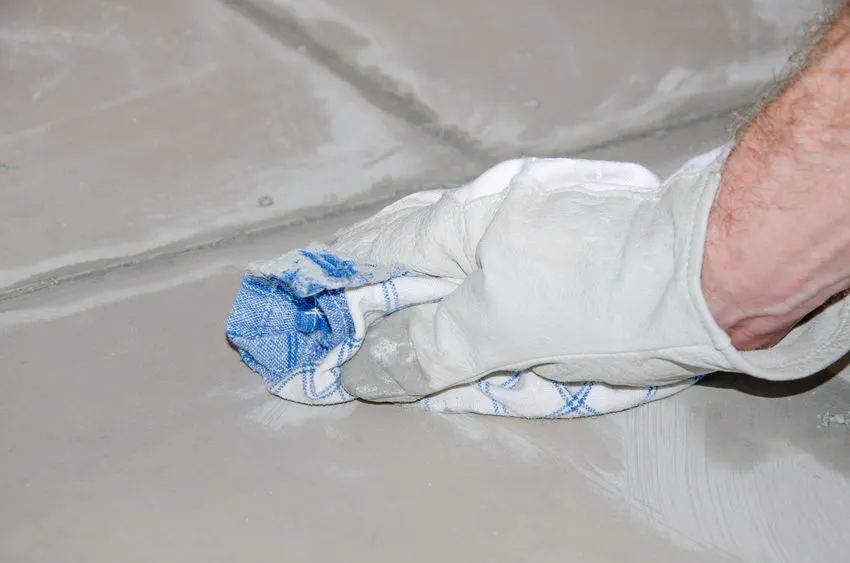 Wiping grout haze from a floor tile