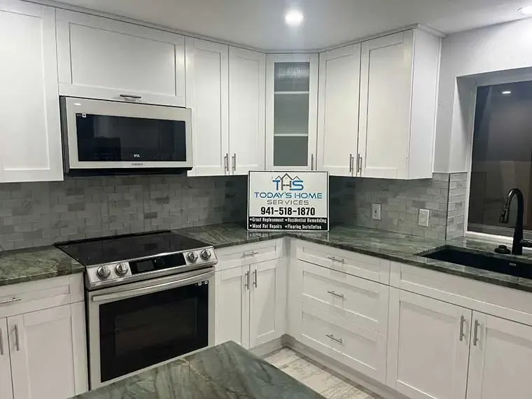 White kitchen with gray subway backsplash and stainless range