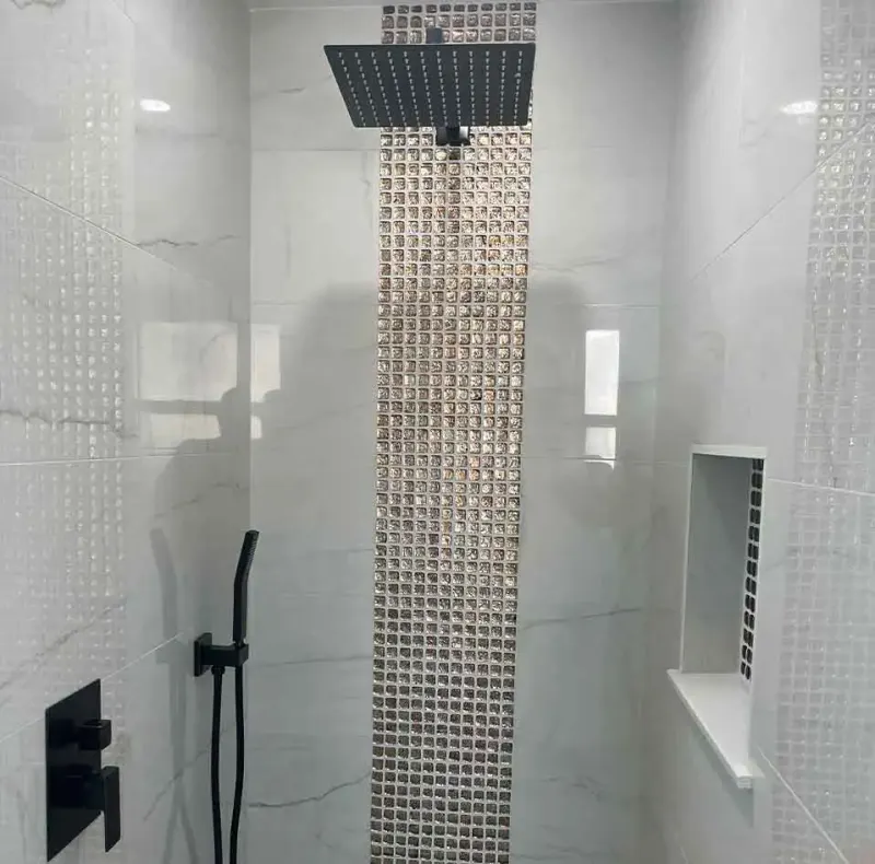 Tiled shower with vertical glass mosaic accent strip, rain shower head and niche
