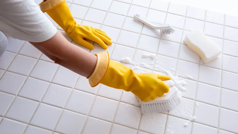 Scrubbing white tile with a brush