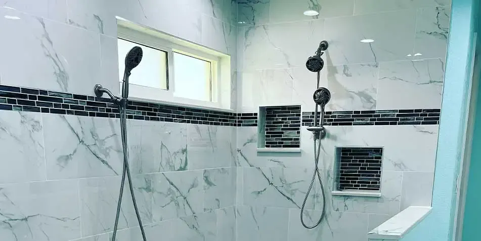 Remodeled walk-in shower with large-format marble-look tile and dual shower heads